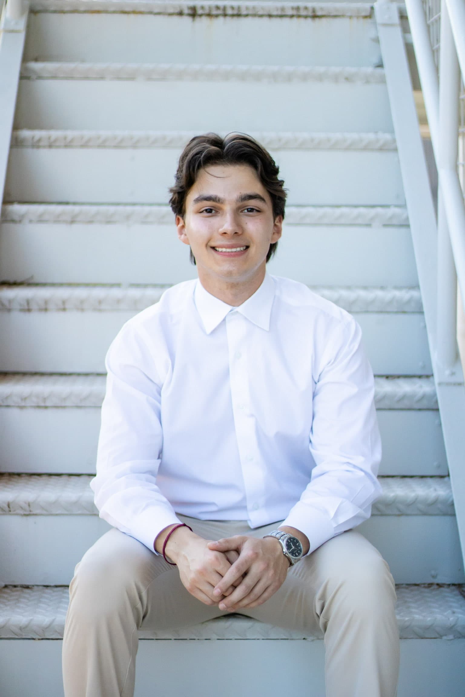 Evan Perkins sitting on stairs in dress clothes